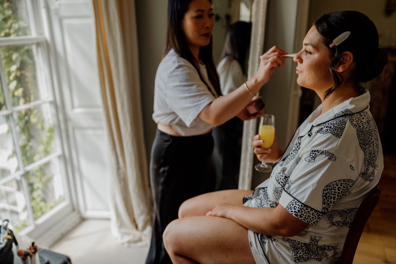 Getting ready scene near a bright window with pre-wedding preparations in progress.