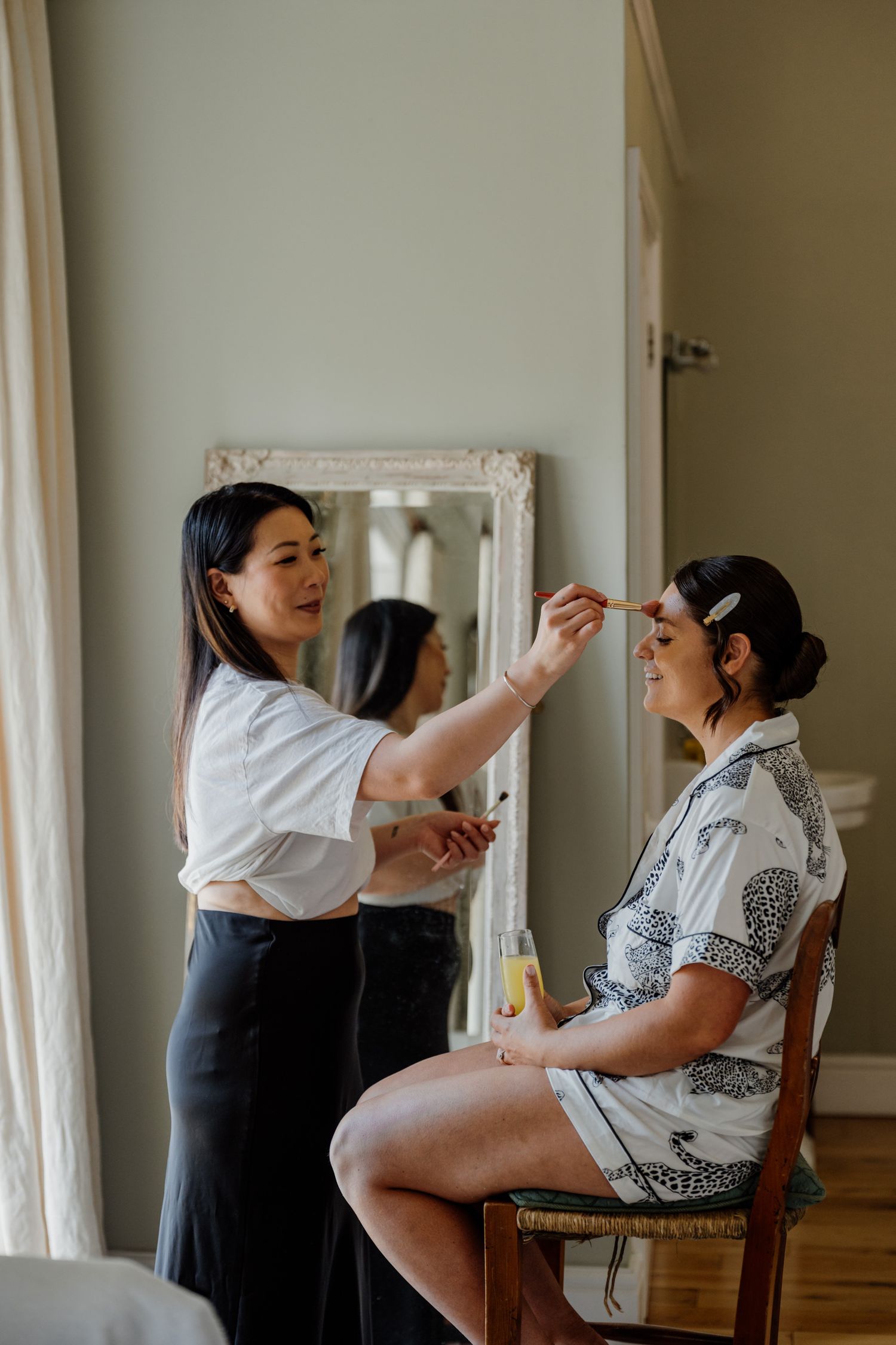 Getting ready moments showing makeup application in a bright room.