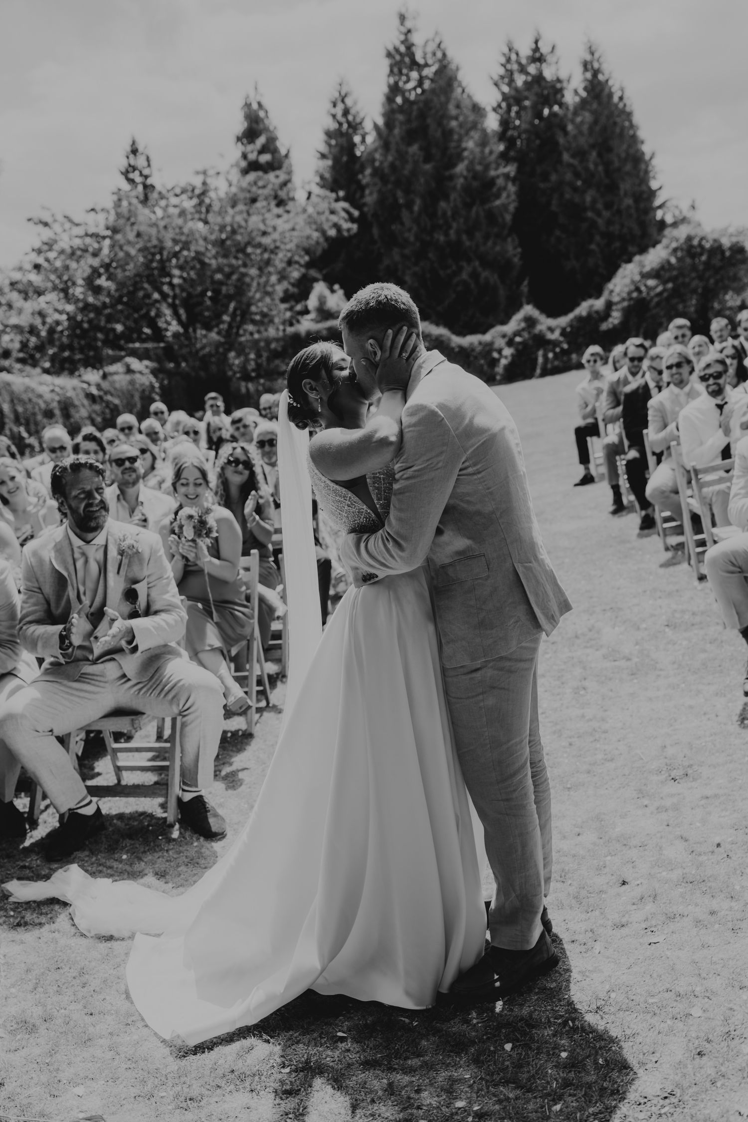 Black and white series captures couple's first dance surrounded by guests at outdoor ceremony.