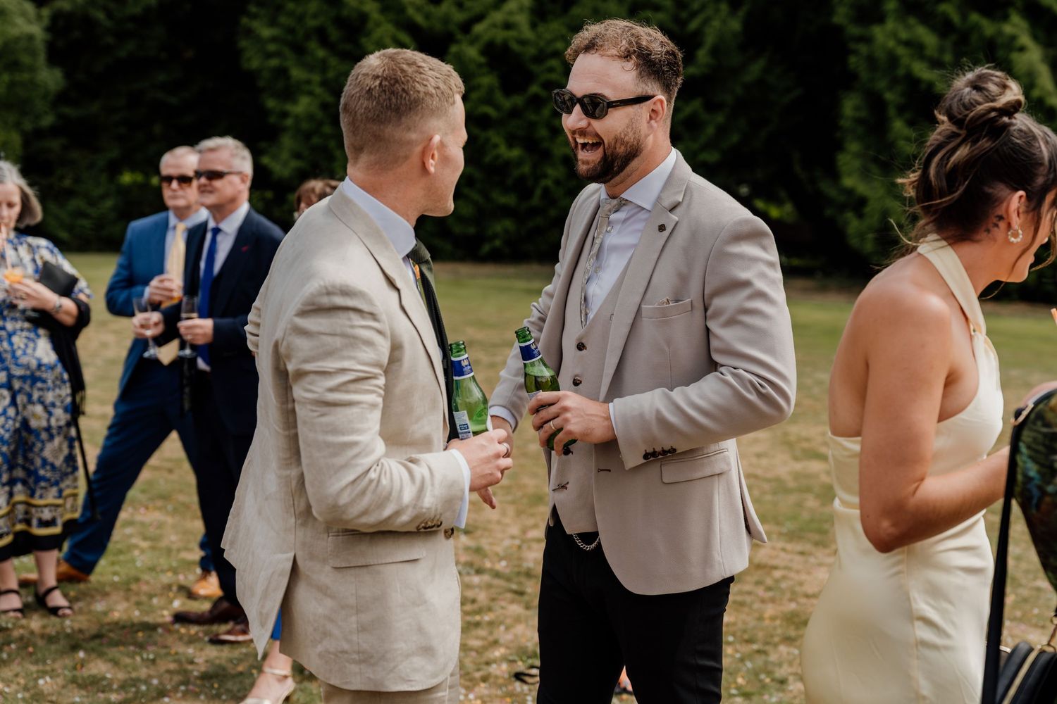 Wedding attendees mingling and chatting during an outdoor summer celebration.
