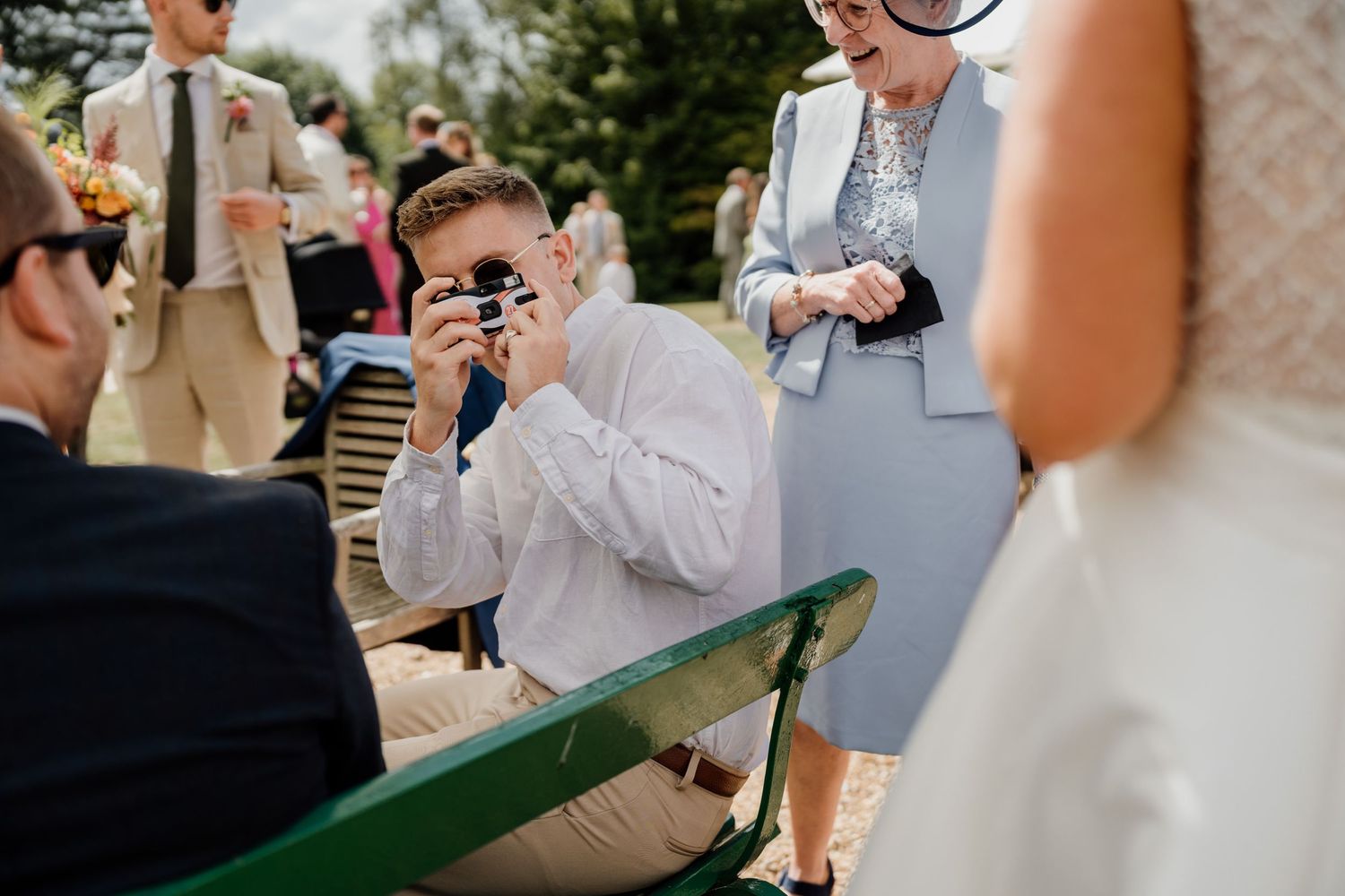 Wedding guests capture photos during an outdoor celebration.