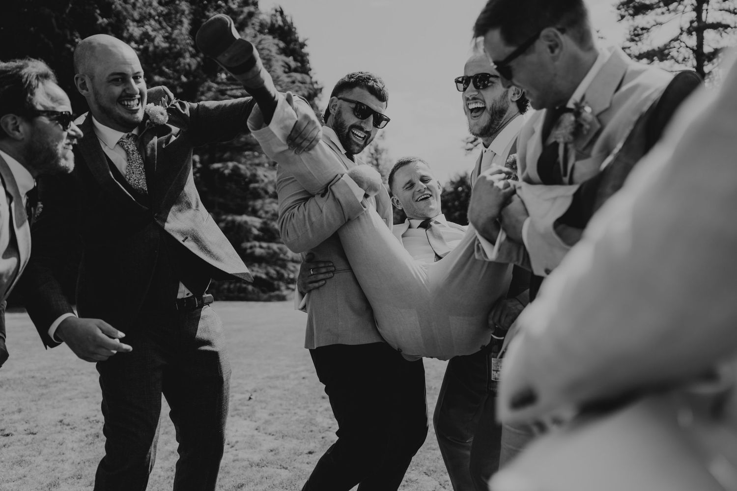 Black and white photo of wedding guests celebrating with joy and excitement.