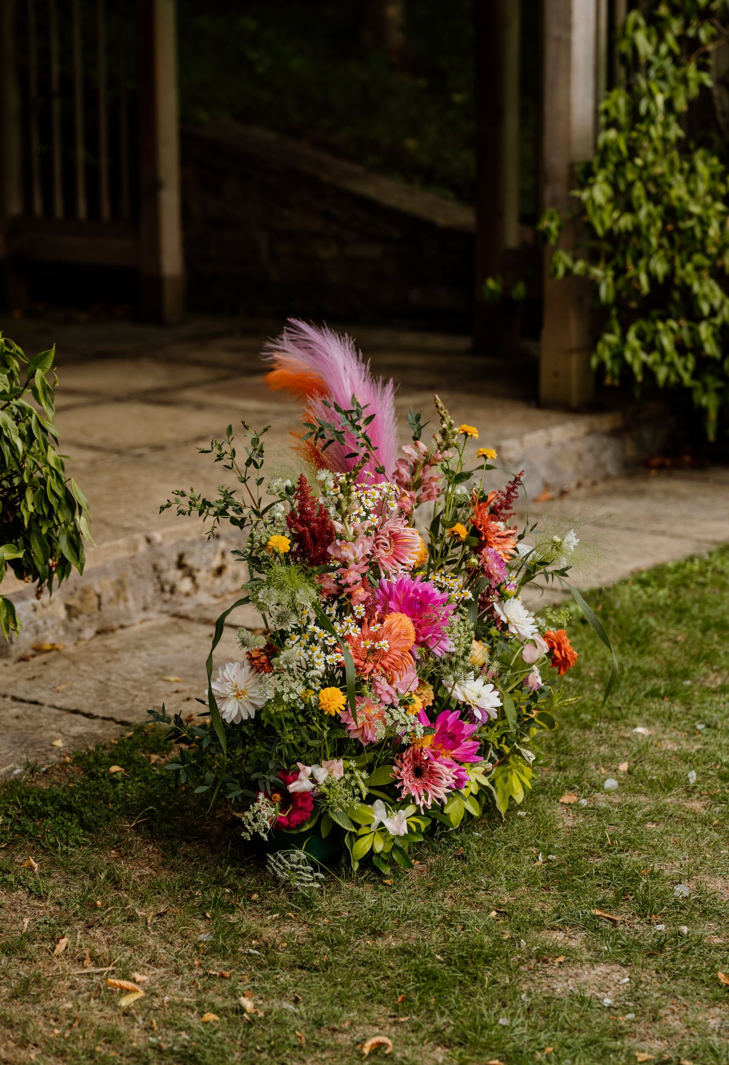 Colorful wildflower bouquets with pink and orange blooms arranged on grassy ground.