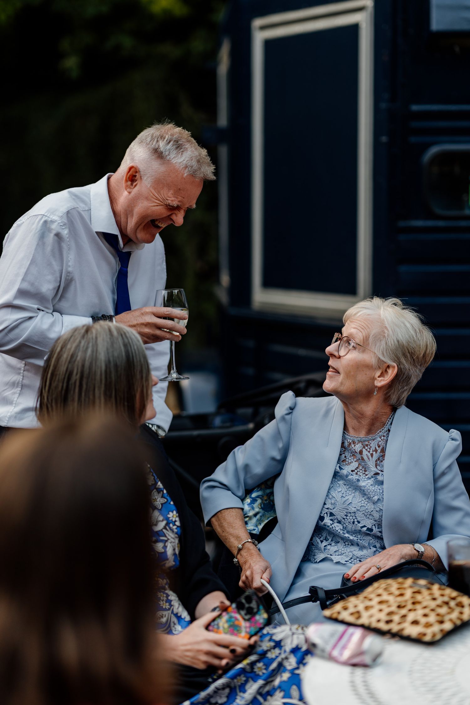 A touching moment of care and connection at an outdoor gathering with refreshments.