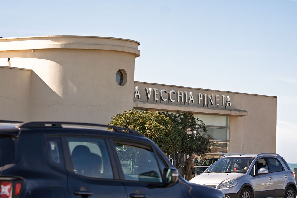 Exterior view of a shopping center with parked cars and storefront signage.
