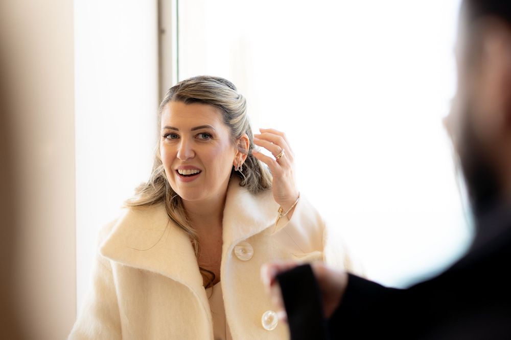 Two people engaged in an animated conversation at a brightly lit professional meeting or event.