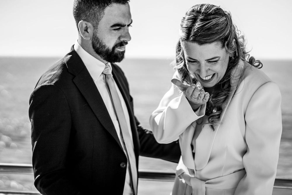 Black and white candid photo of a couple sharing an intimate moment together outdoors.