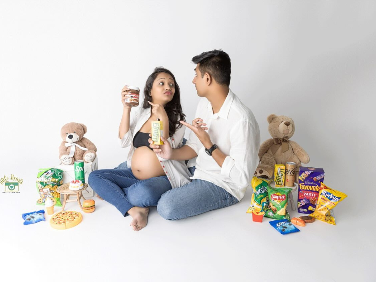 Mother and baby lying on white background surrounded by snacks and toys in progressive stages of composition.