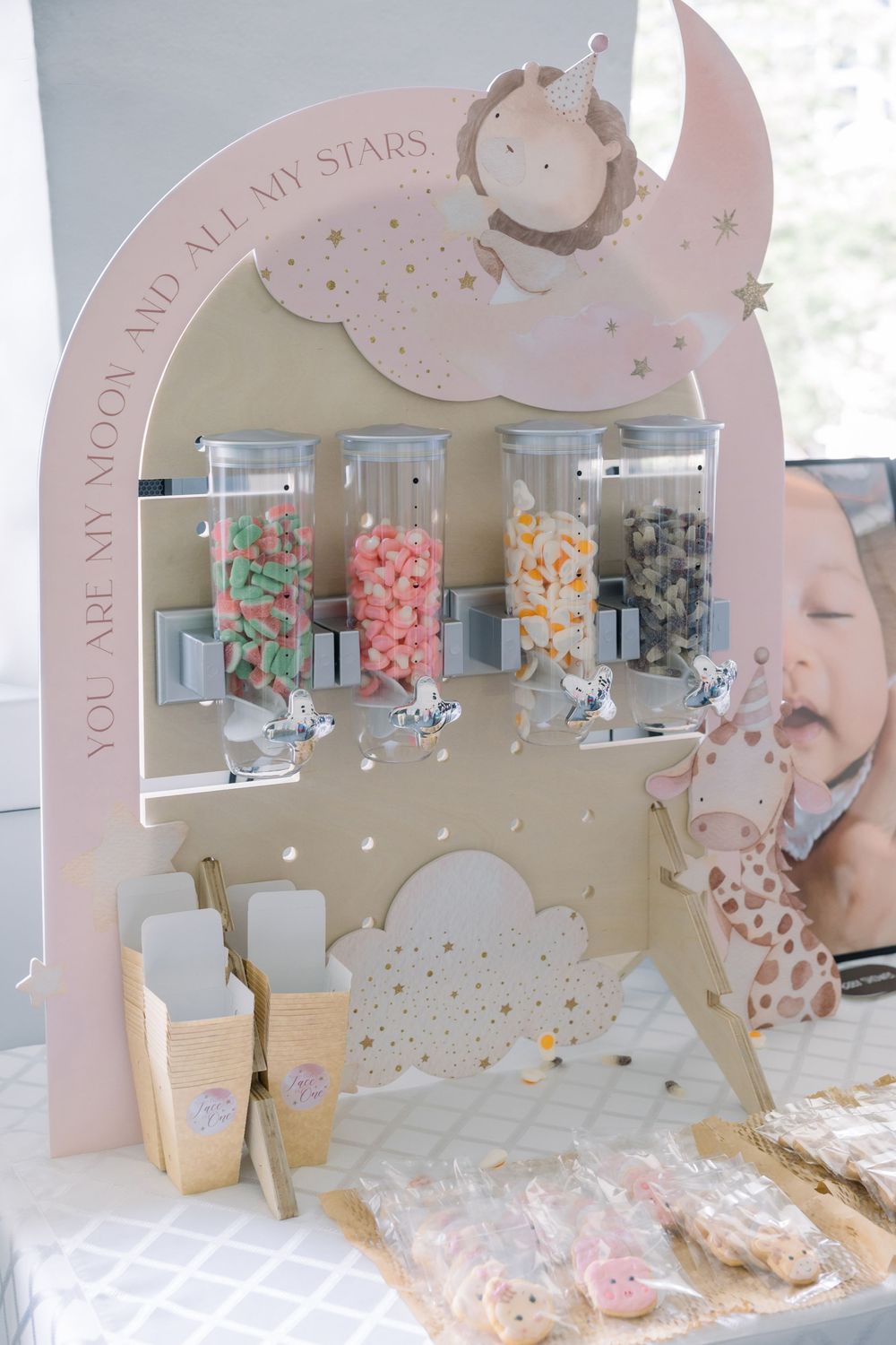 Retail jewelry display showcasing colorful earrings and accessories against a pink backdrop with moon and star decorations.