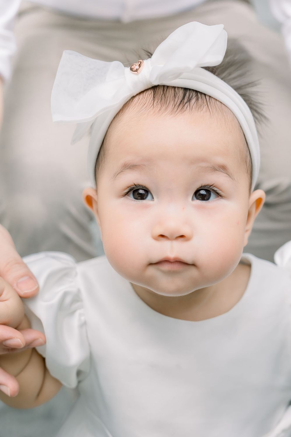 A close up photo composition showing four soft-focused views of an infant wearing a white hat and clothing.