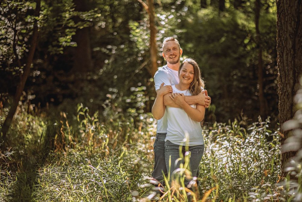 Romantic photoshoot in a sun-dappled forest clearing.