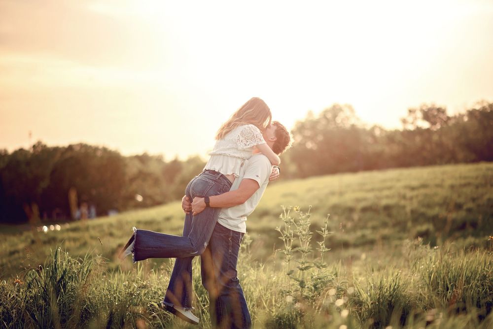 Fun lifestyle photography session in a grassy field during golden hour.