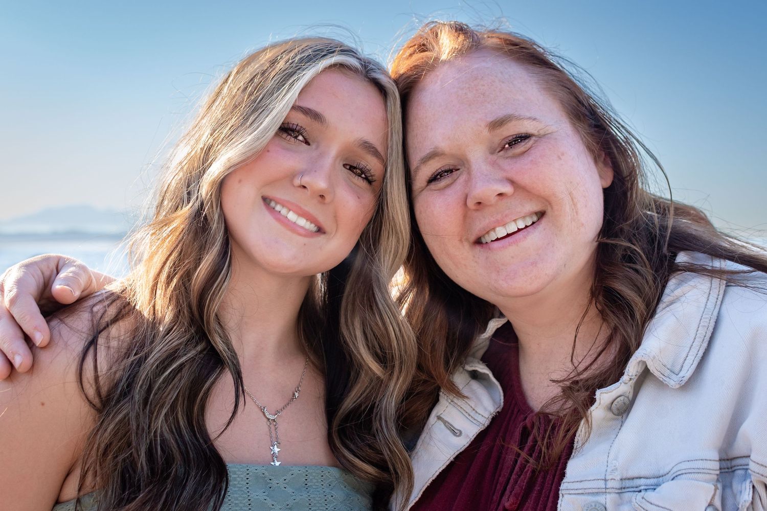 Senior girl and her mother smiling together during Alki Beach senior portraits in Seattle.