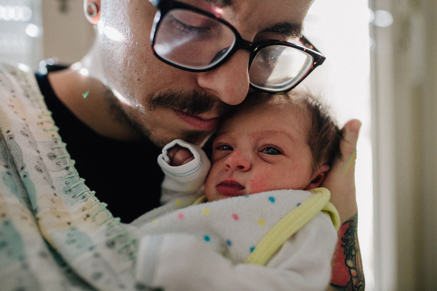 Tender moment between parent and newborn baby in intimate close-up.