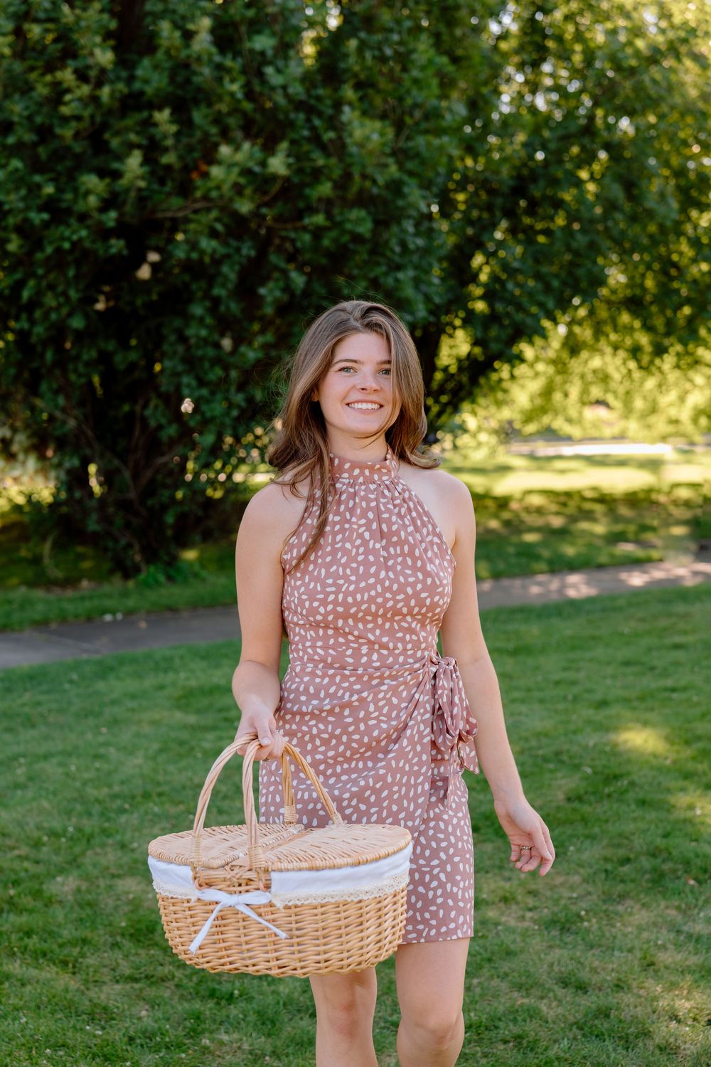 A sequence of photos shows someone in a floral dress holding a white picnic basket in a sunny garden setting.