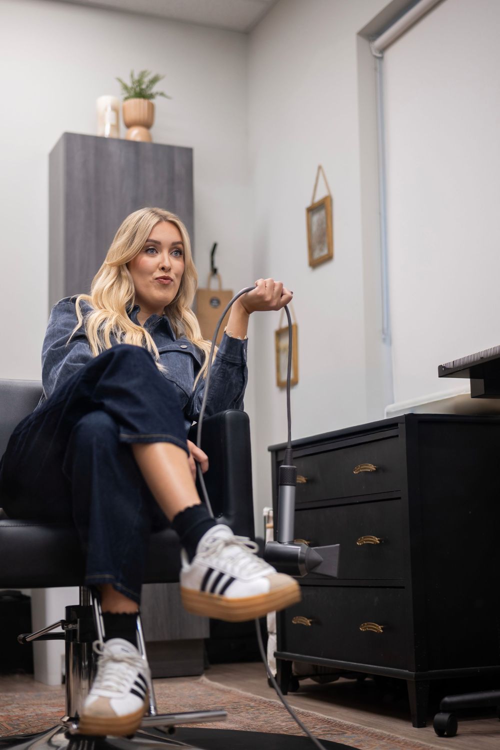 A series of five photos showing someone in a navy dress sitting at a black piano wearing white Adidas sneakers.