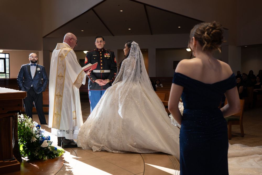 Military wedding ceremony taking place in a church with priest performing the service.