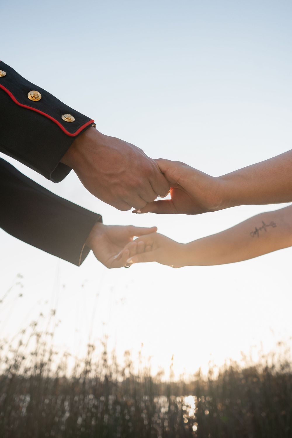 Close up of hands holding against a sunset sky background.