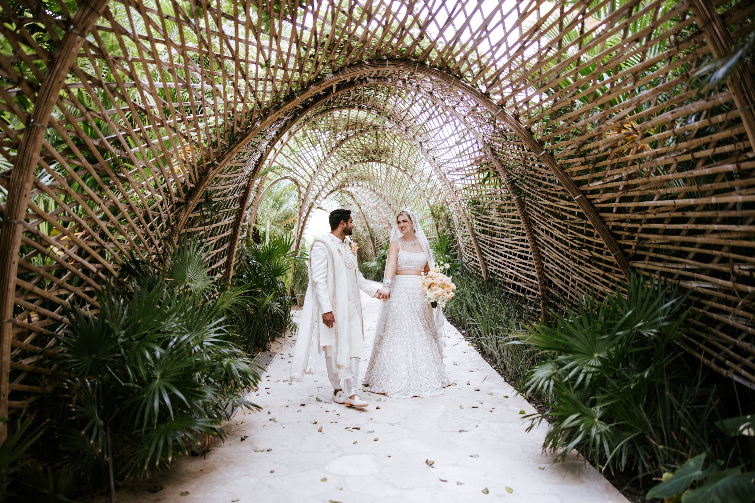 Indian couple captured during their wedding session, showcasing a spectacular beaded wedding dress in the iconic hallway of Secrets Moxché