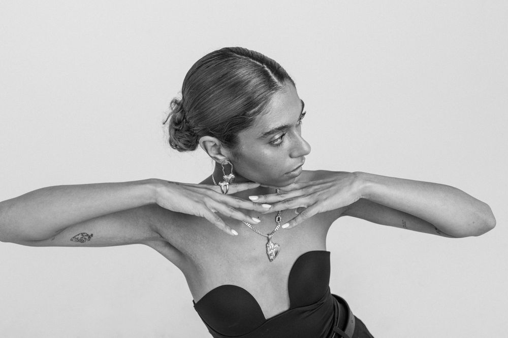 Dramatic black and white portrait of a dancer striking an elegant pose in a black strapless top.