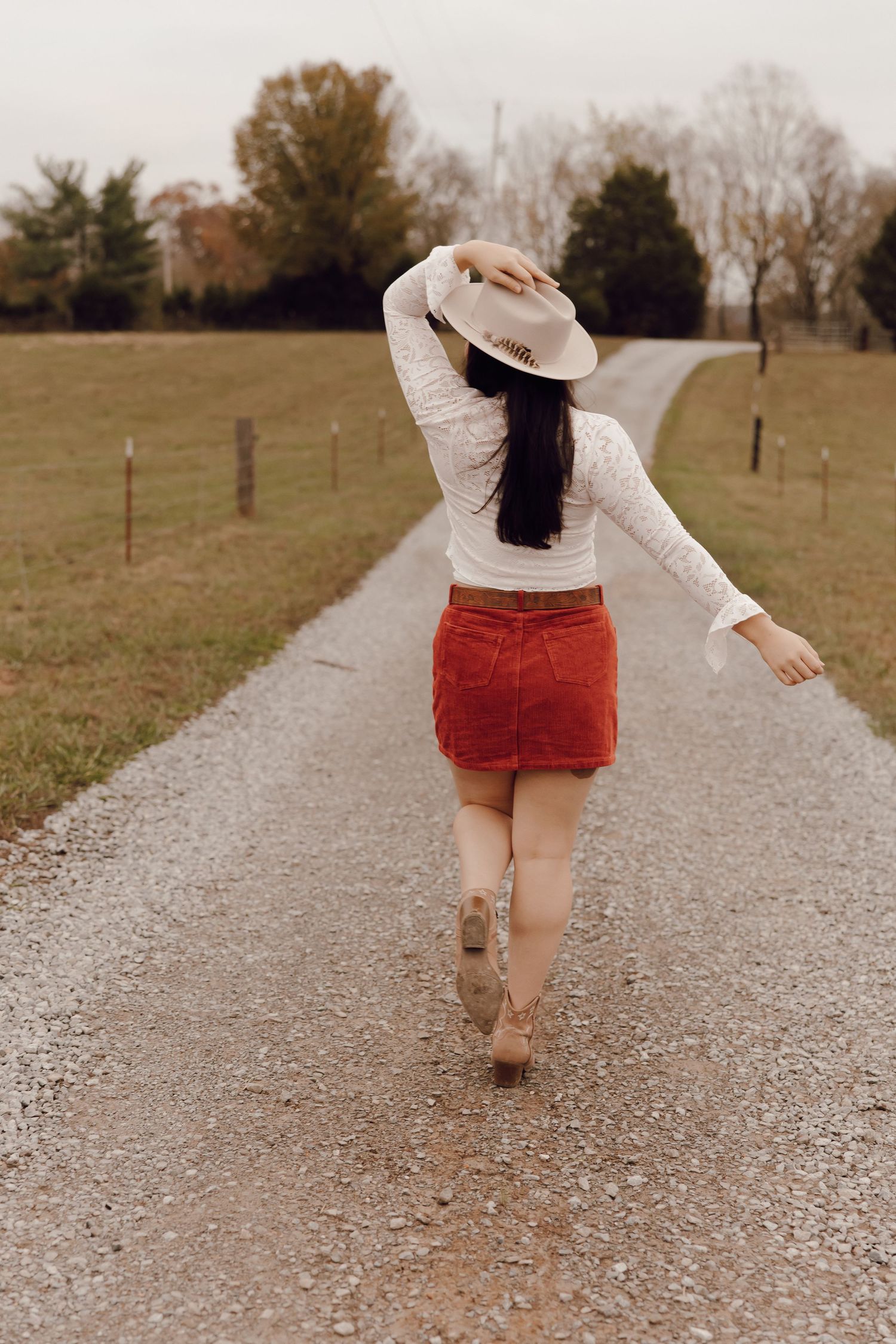 Senior graduate celebrating with a diploma, captured during an outdoor photoshoot.