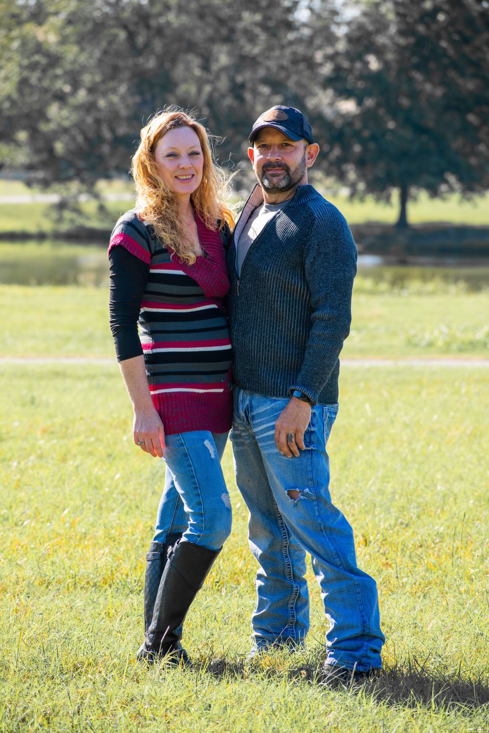 A man and a woman pose in a sunny field, embodying a sense of peace and companionship in the great outdoors.