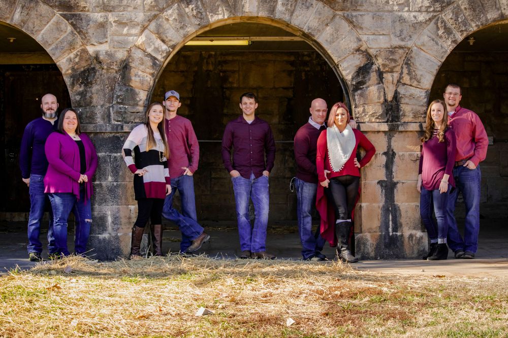 A group of individuals standing together in front of a decorative archway, showcasing camaraderie and joy.