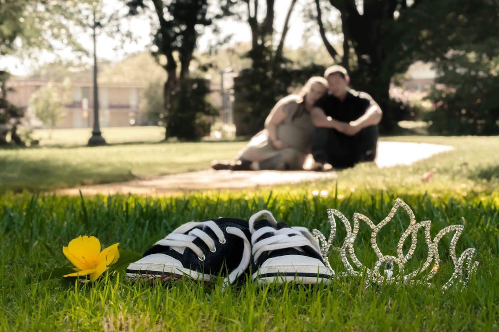 A crown and sneakers on grass, representing the delightful news of a baby girl arrival.
