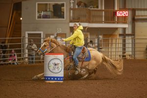 Goat tying competition at a rodeo arena with multiple riders practicing their technique in sequence.