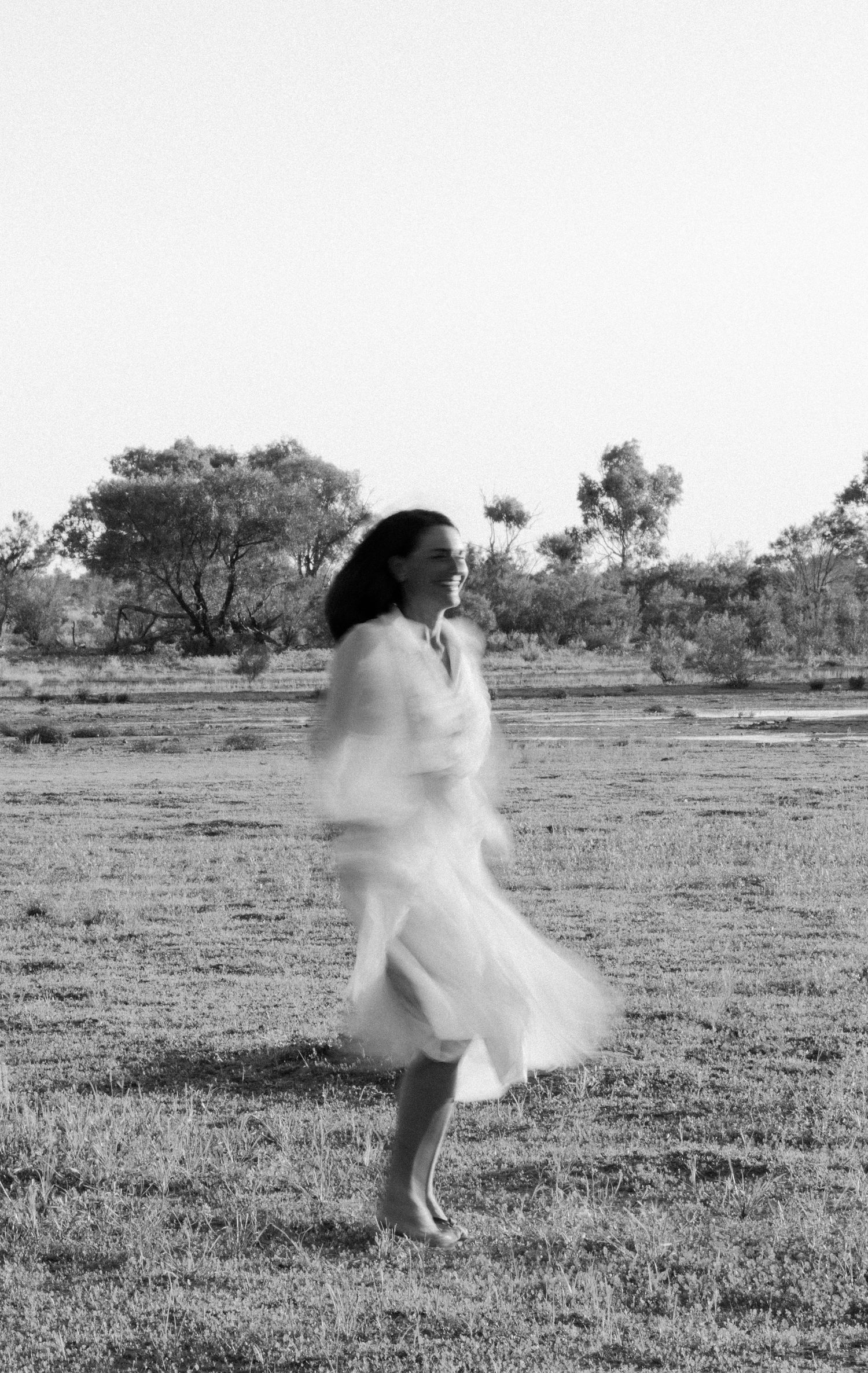 A flowing white dress twirls gracefully in the Australian outback.