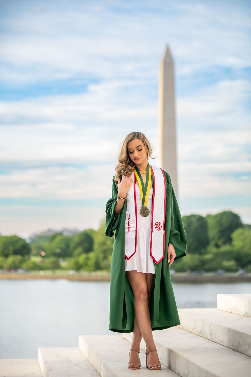 Graduation portraits at Jefferson Memorial showcasing green regalia and ceremonial stoles.