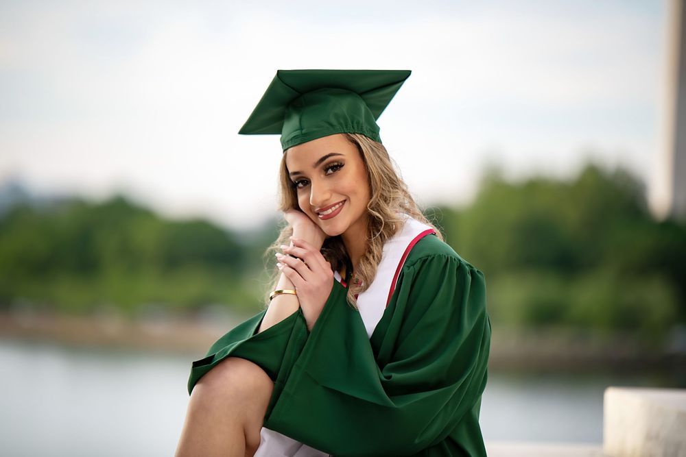 Multiple views of graduate posing in green academic regalia against marble columns.