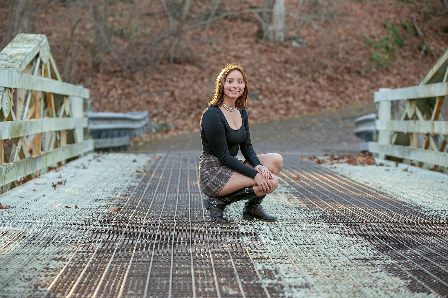 Engagement photos on wooden bridge surrounded by autumn foliage.