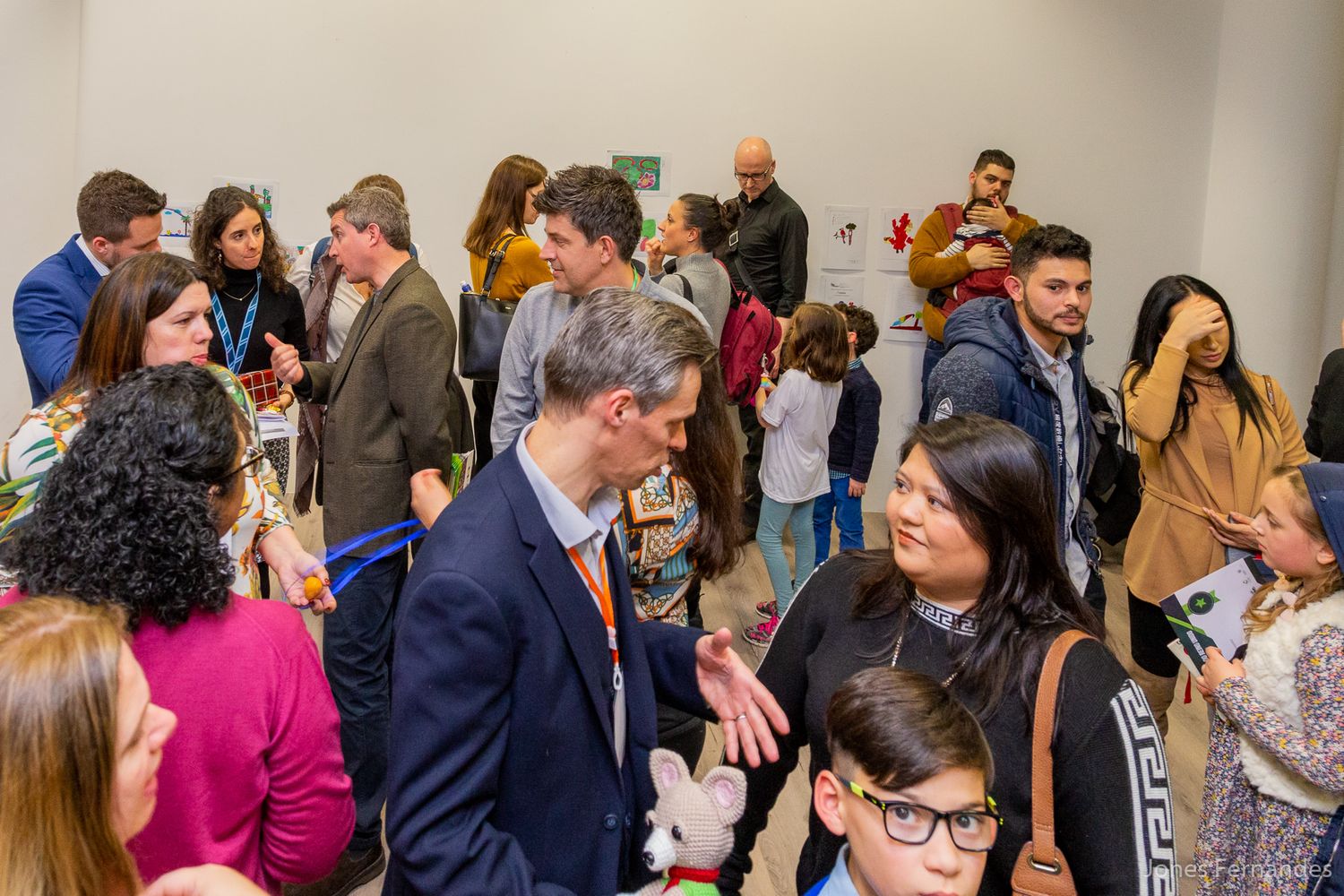 A crowded networking event shows people mingling and conversing in a bright room during a professional gathering.