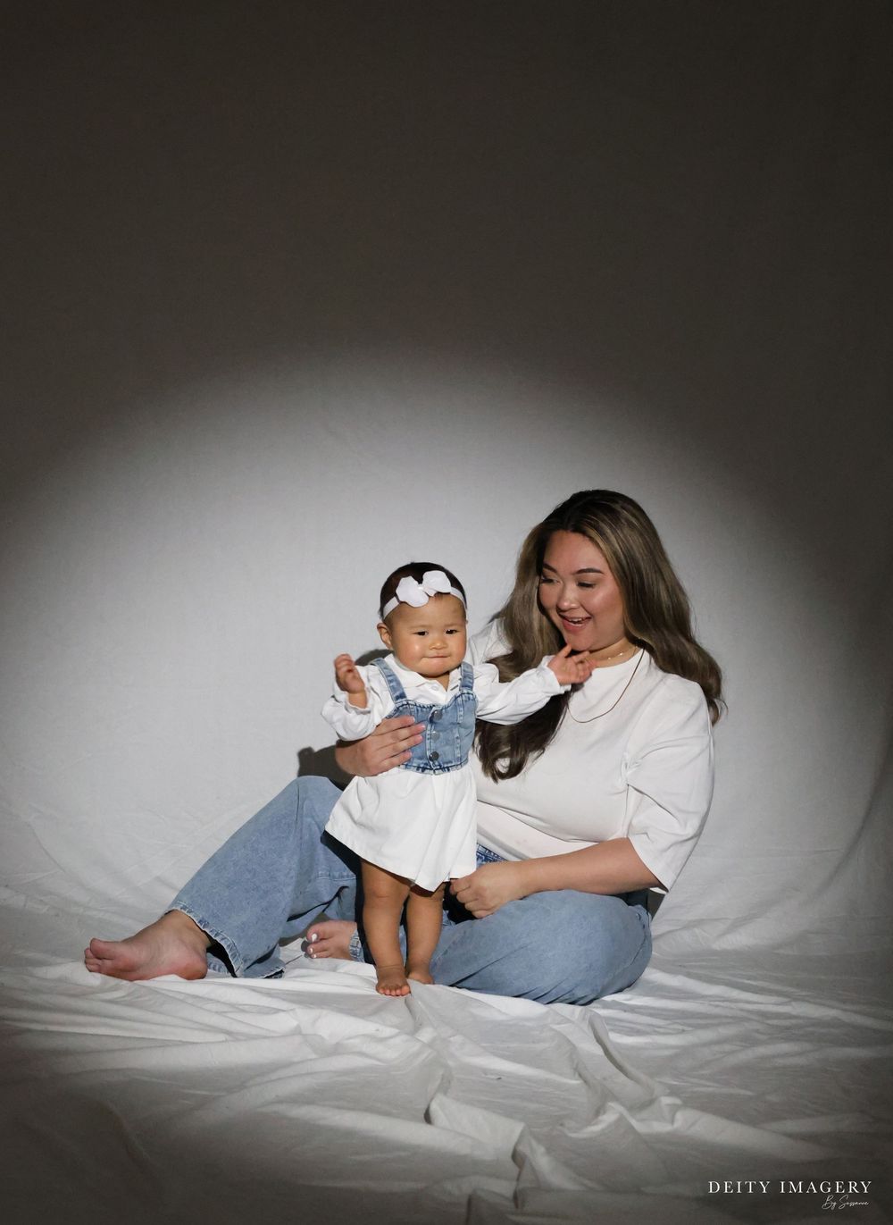 A series of intimate lifestyle portraits showing a tender moment between parent and child on white bedding.