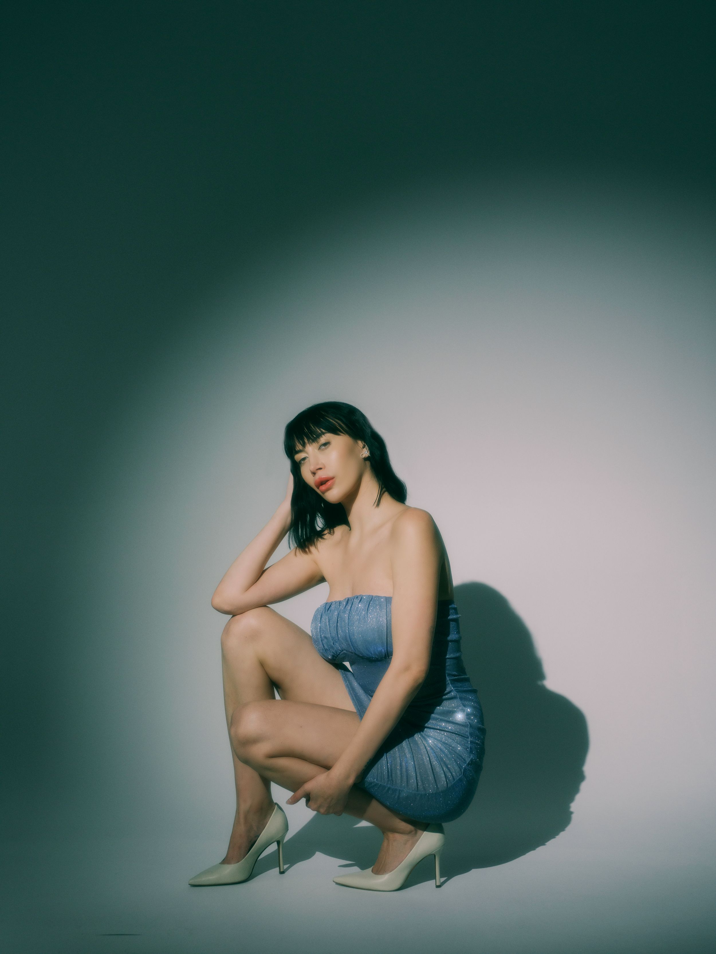 Stylish fashion portrait featuring a denim dress and high heels against a gradient background.
