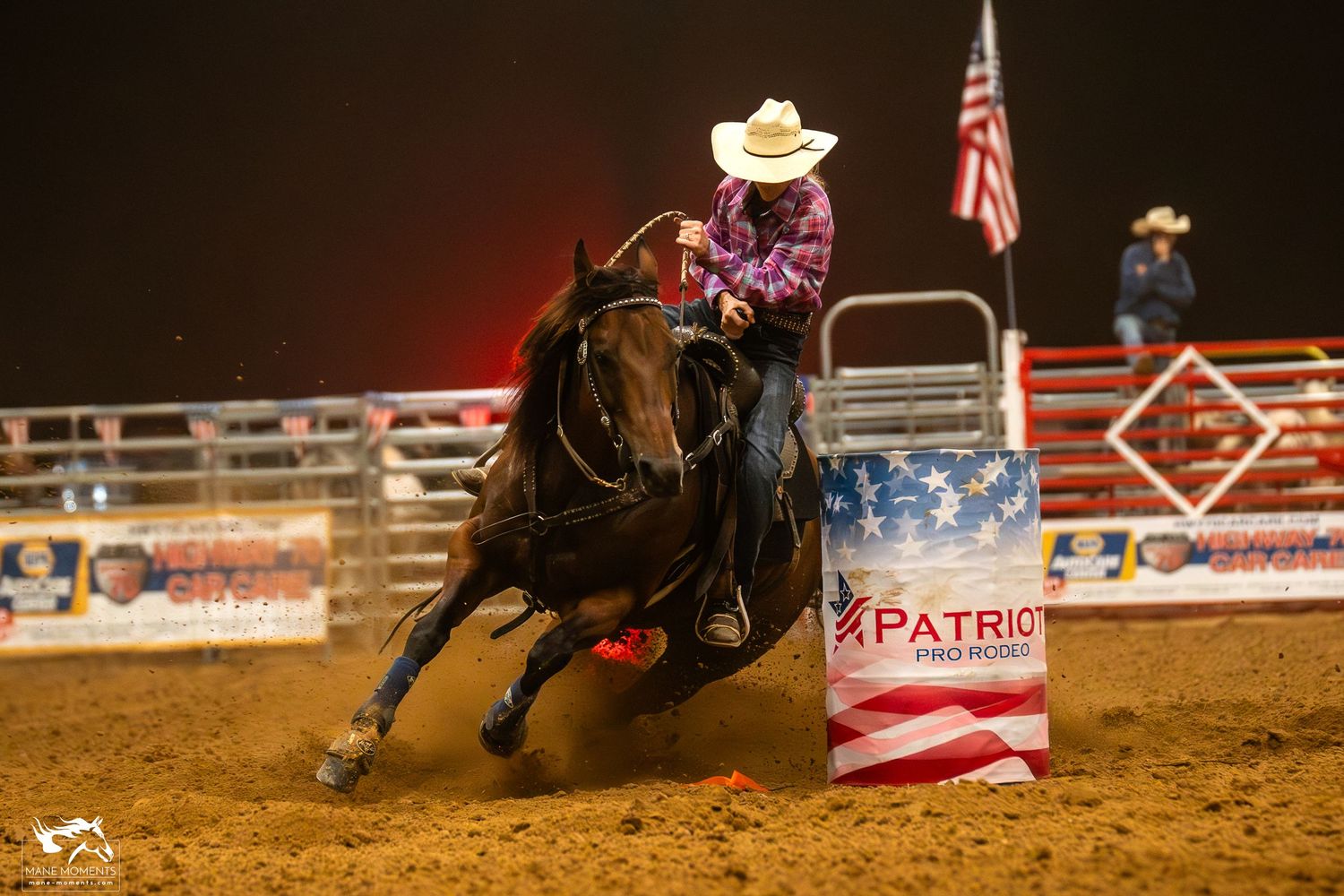 A cowboy rides a bucking horse during a professional rodeo competition event at a western arena.