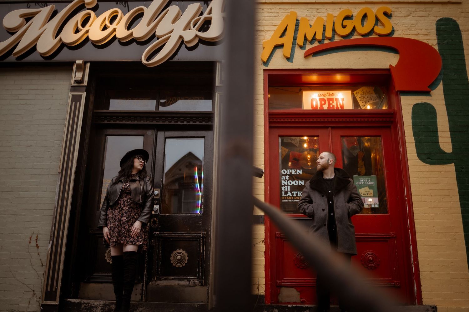 Two restaurants with illuminated storefronts at night, one labeled Moody's and the other Amigos. engagement session