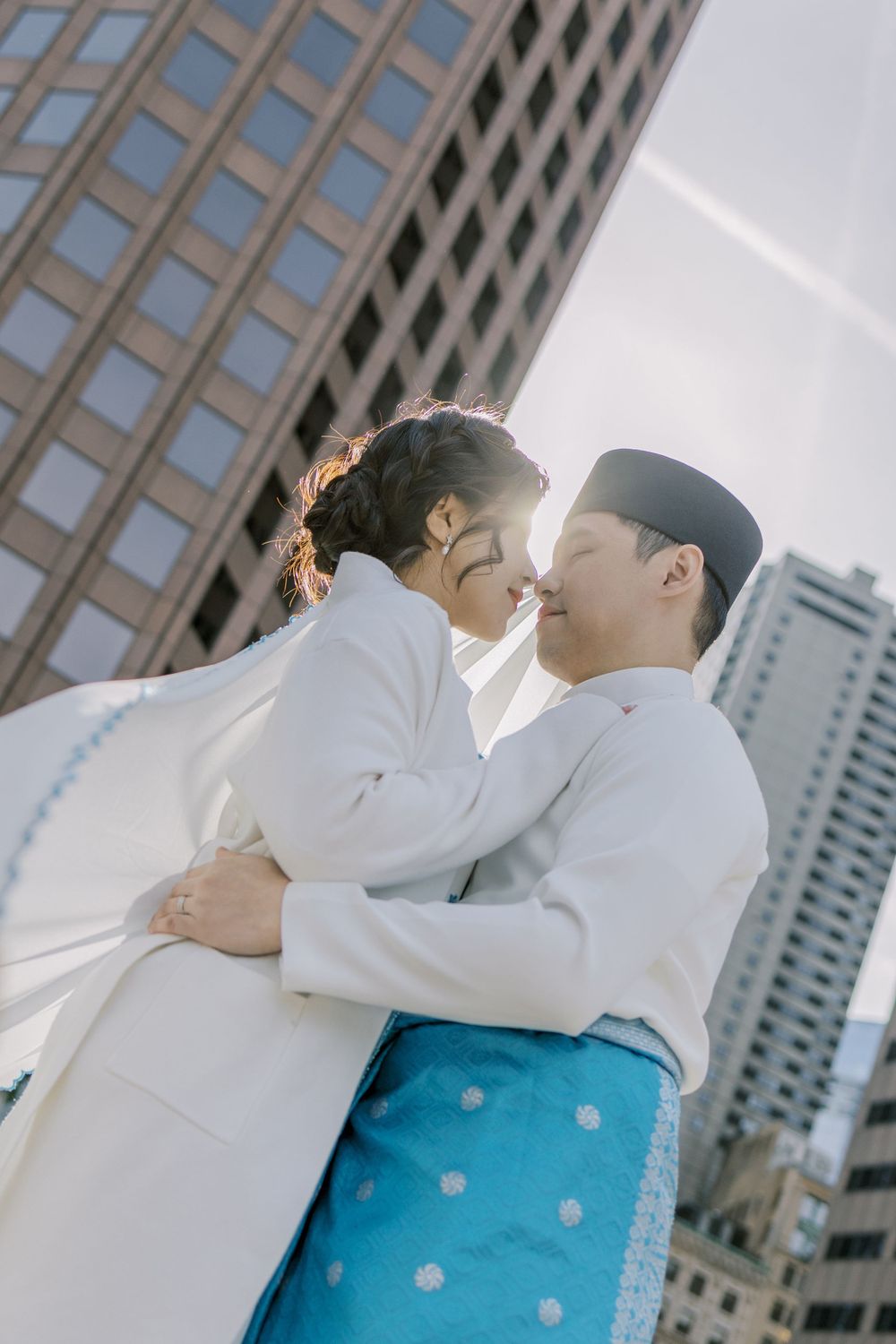 Urban rooftop photoshoot with couple in coordinated white and blue traditional outfits.
