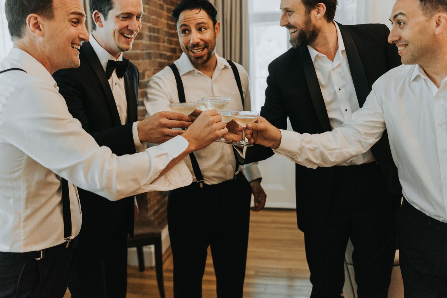 Group of formally dressed people toasting and celebrating together at an indoor gathering.