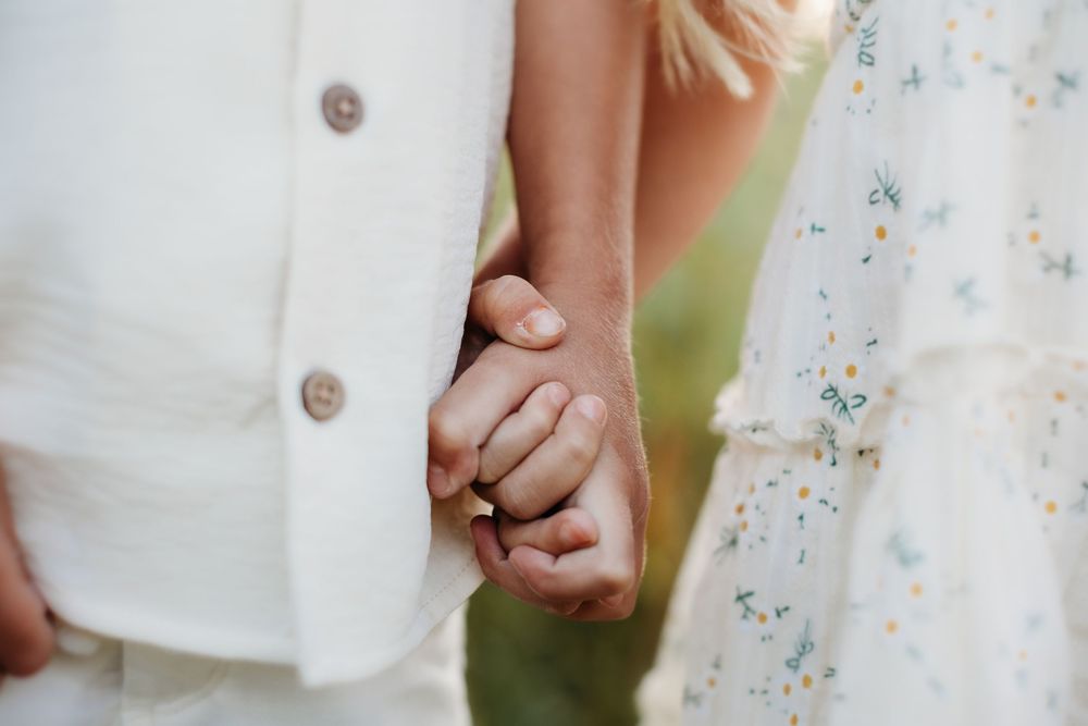 Close-up details of white lace dresses against a natural outdoor background.