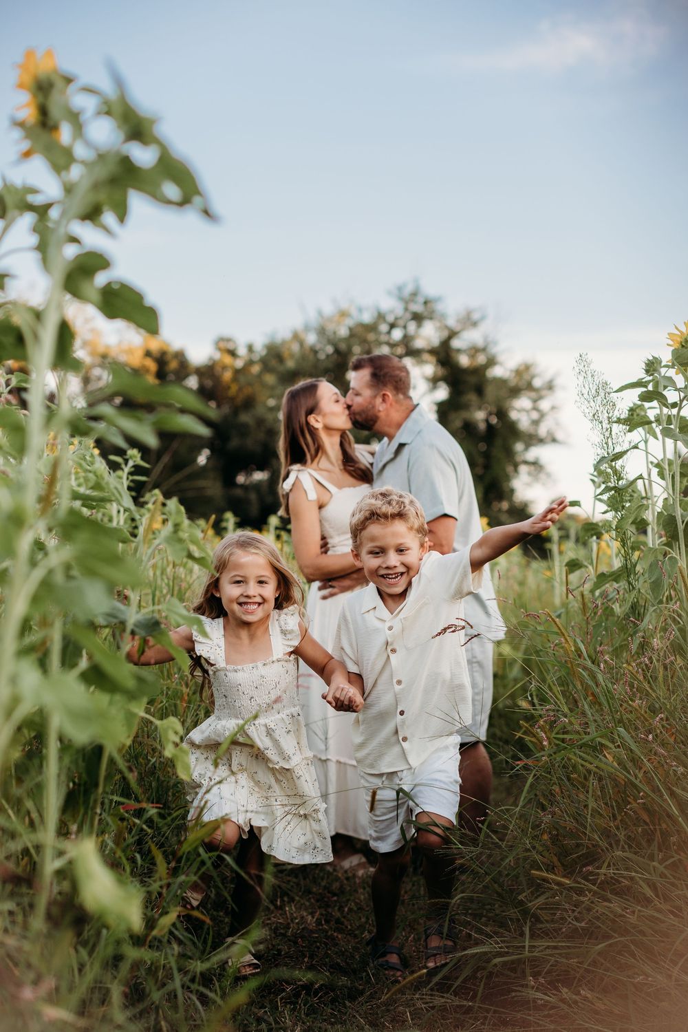 Candid family moments captured in a wildflower field during sunset.