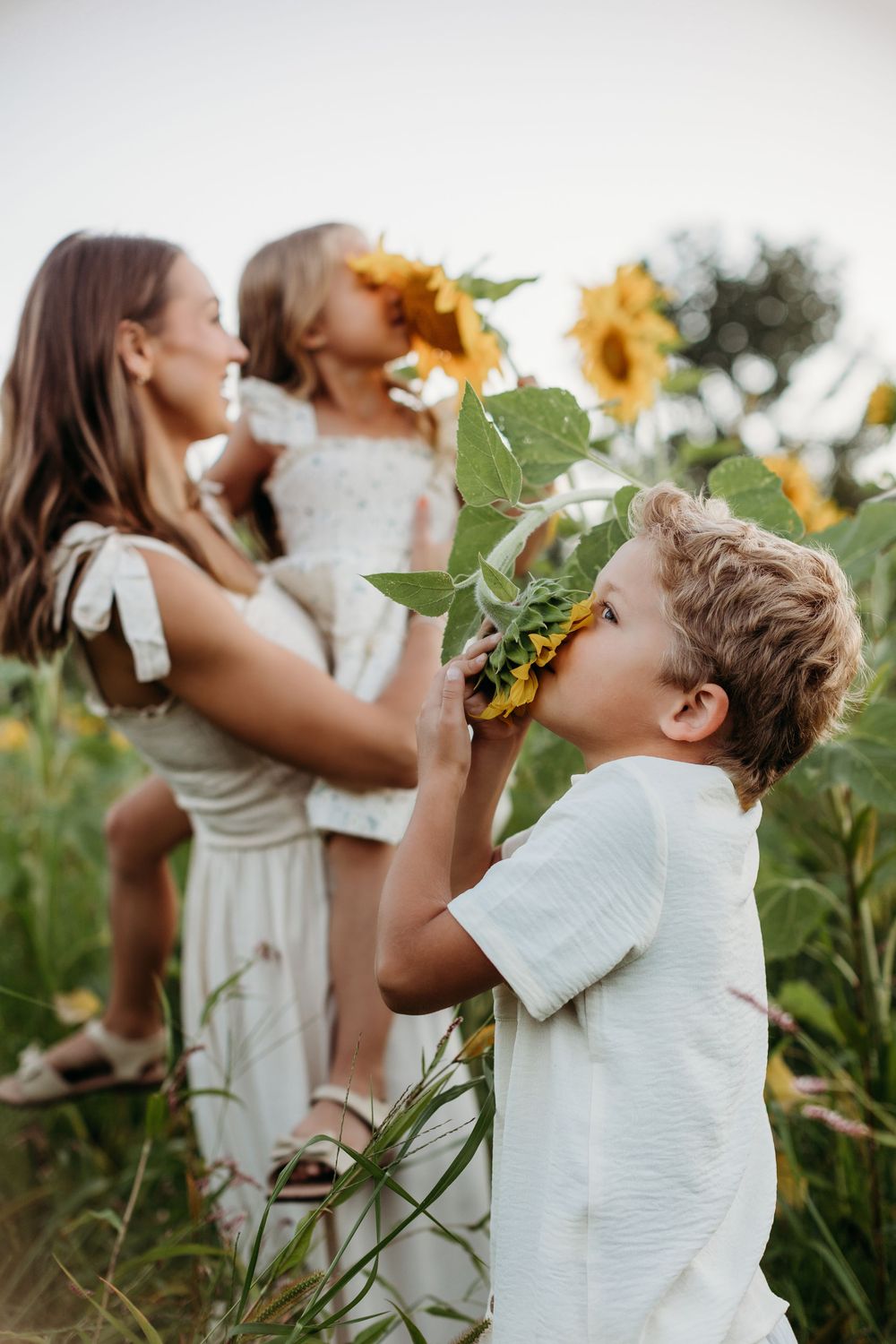 Joyful poses captured in a sunflower field during a summer photoshoot.