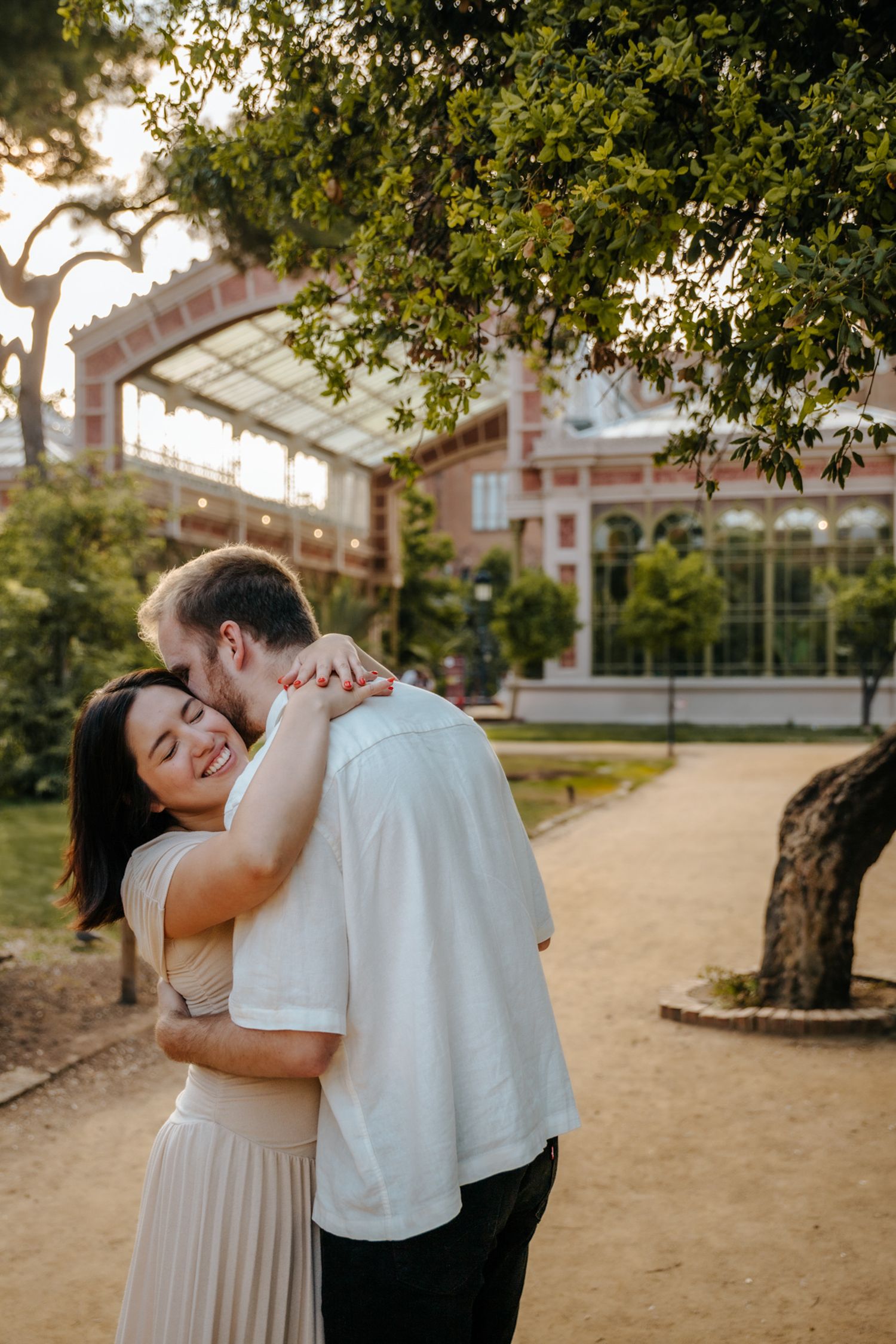 Romantic honeymoon portrait with park greenery as backdrop.