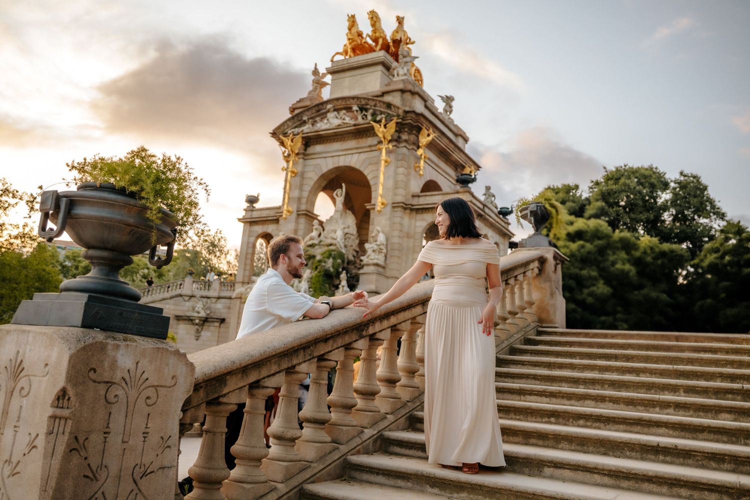Couple walking hand in hand through the greenery of Ciutadella Park.