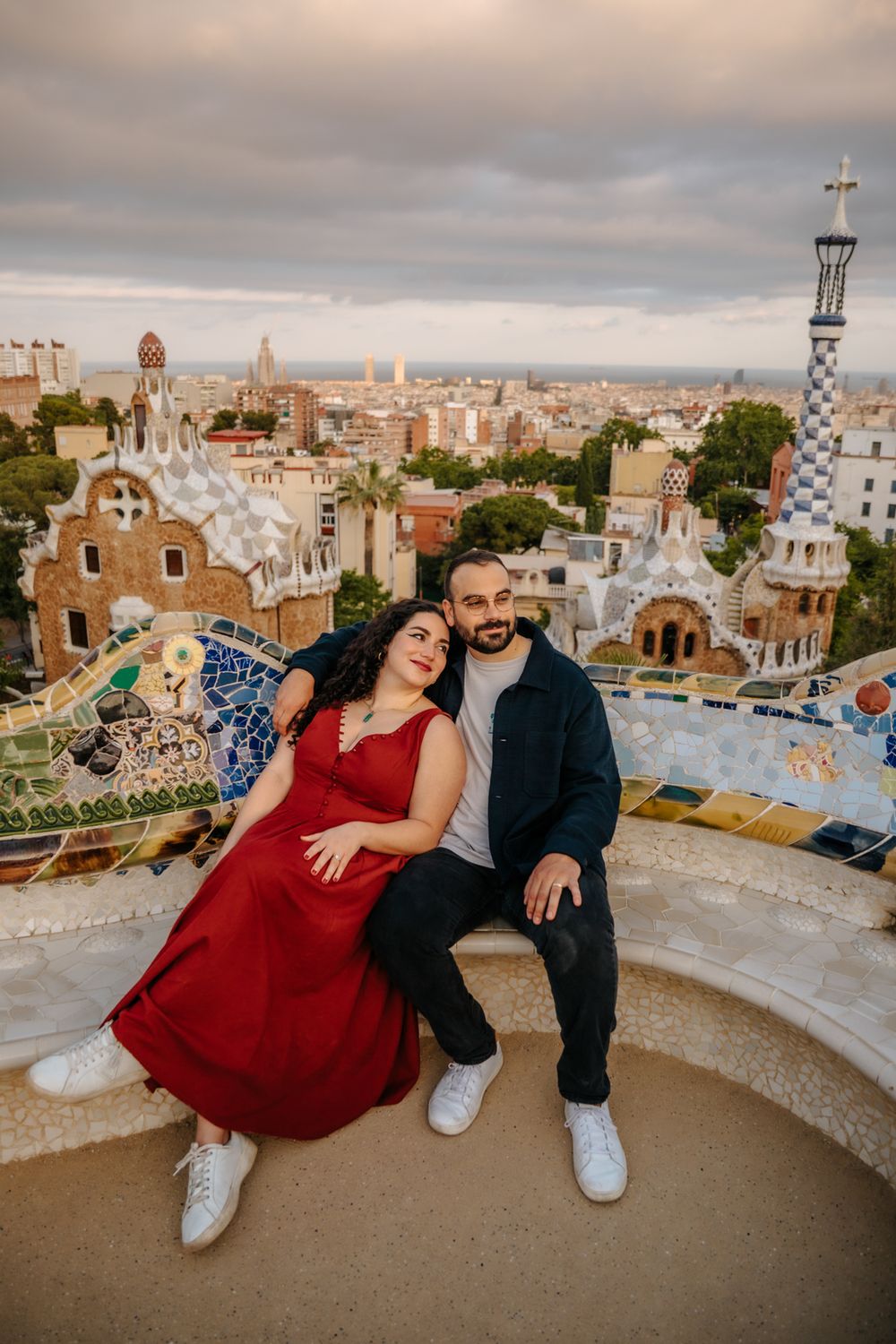 Couple sharing a joyful moment near Park Güell’s whimsical mosaics.