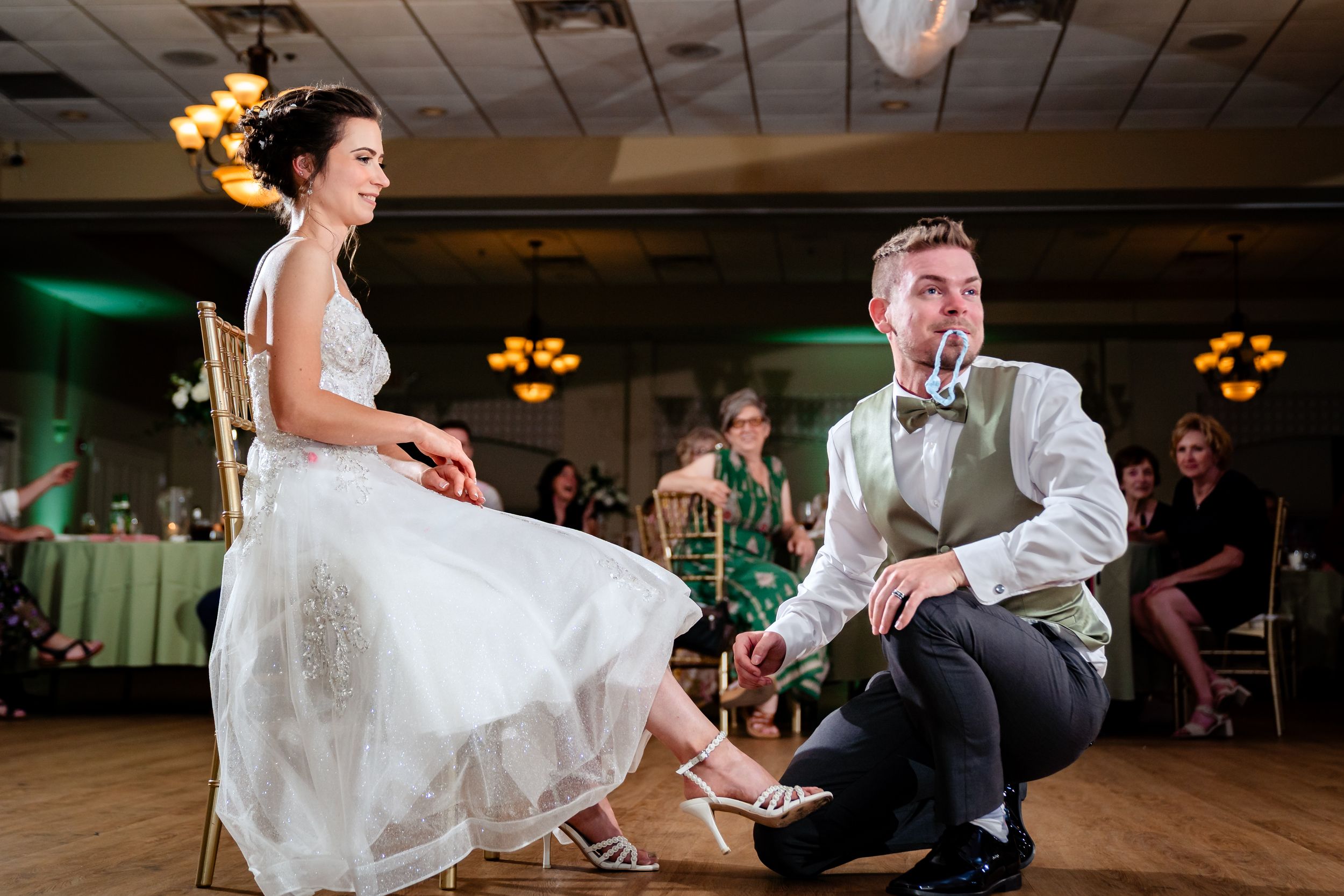 Wedding couple dances together on a wooden dance floor during their reception.