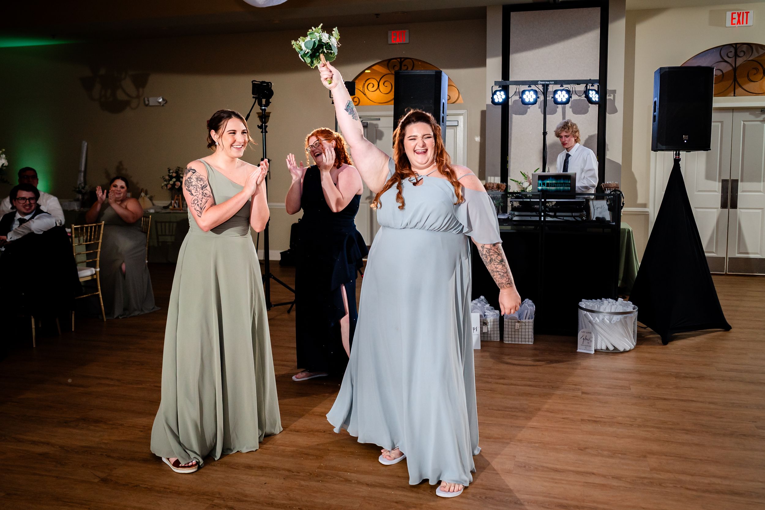 Bridesmaids in soft blue dresses gather on the dance floor during reception.