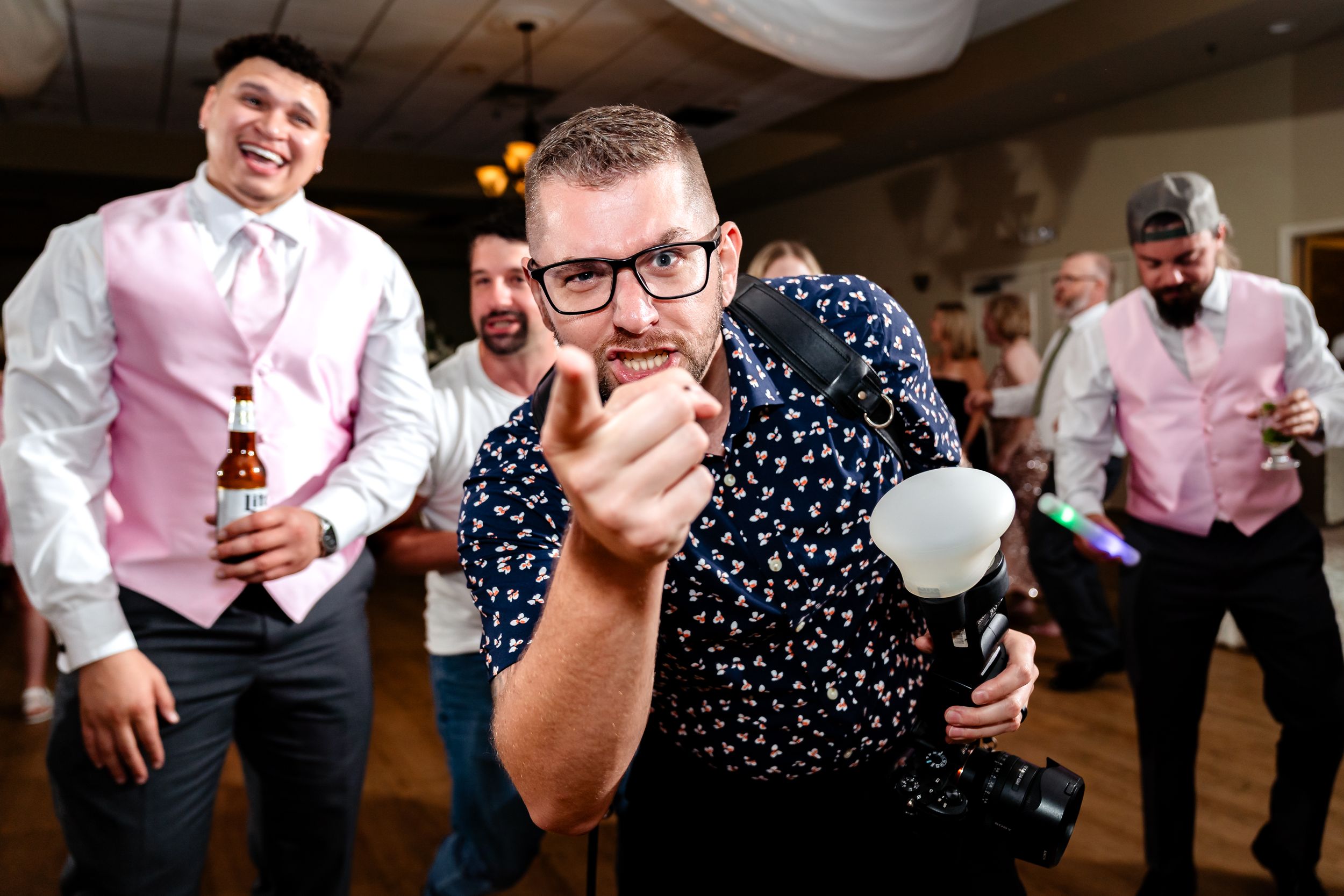 Wedding guests in formal attire enjoying themselves on the dance floor.