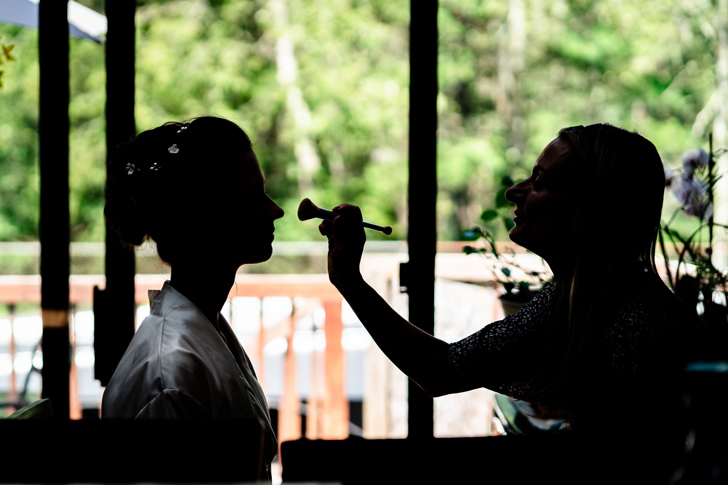 Silhouettes of people seated at a covered outdoor venue.